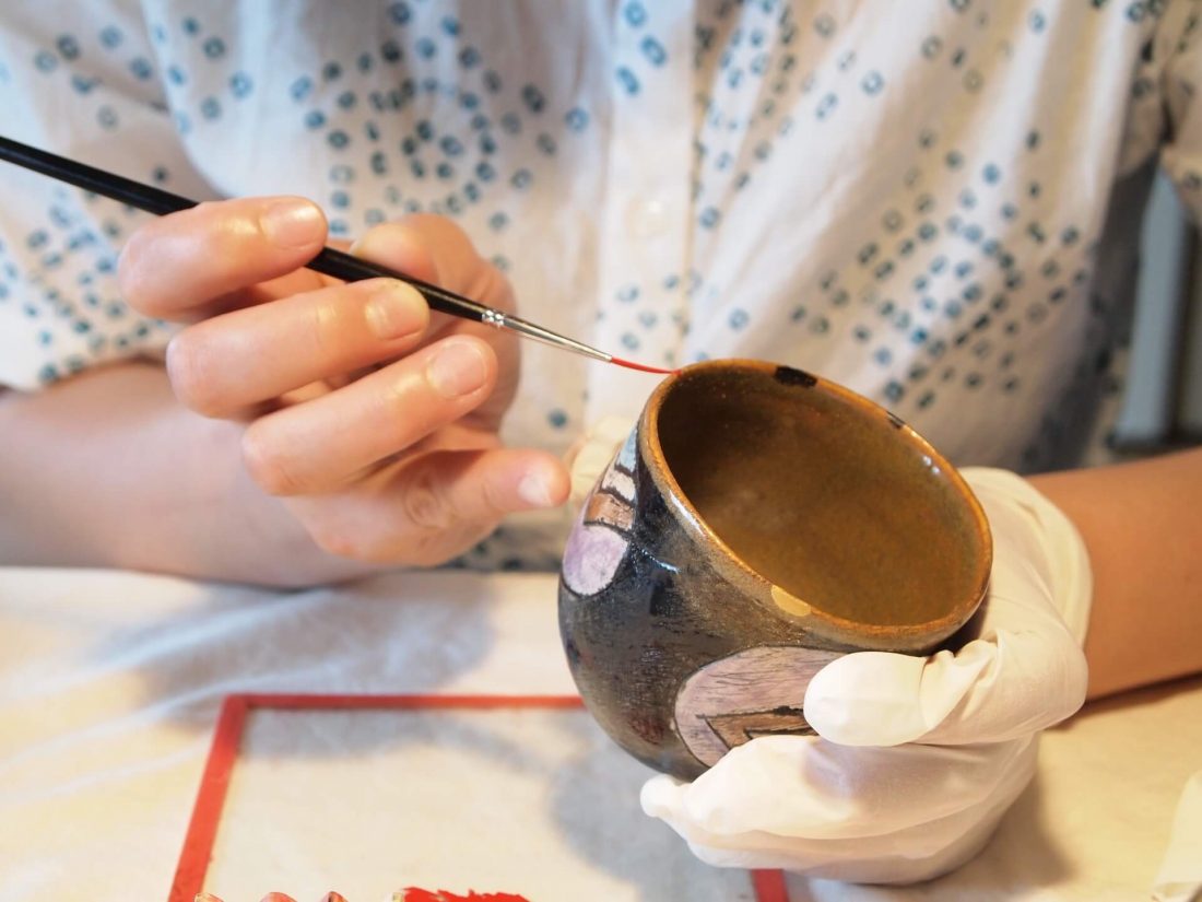 丁寧に彩色される陶器の器