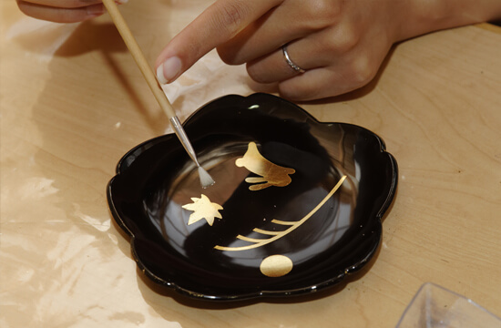 金箔を施す漆器の装飾作業